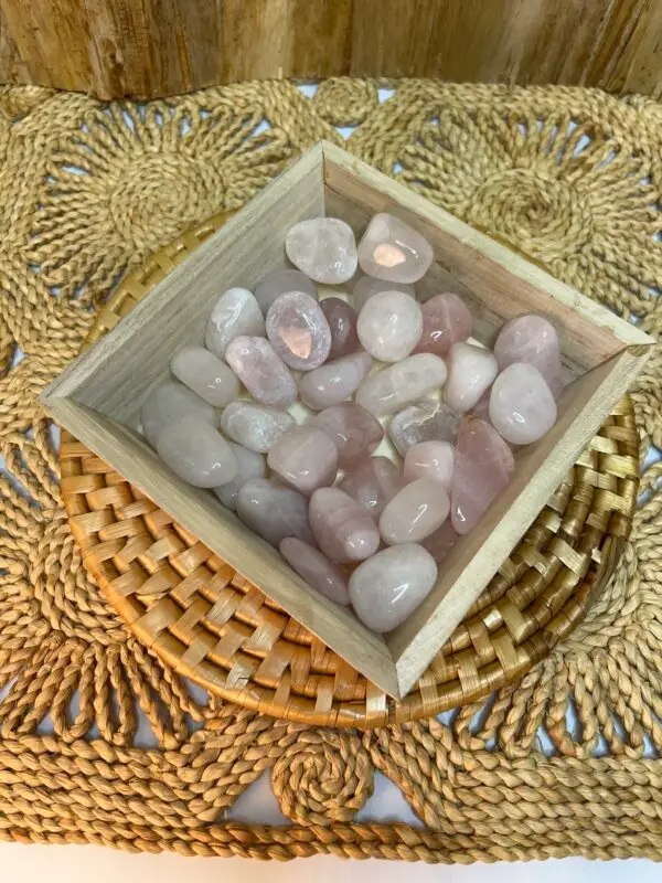 Small pink stones in wooden bowl